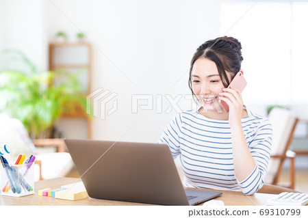 年輕女子在客廳裡做遠程辦公 年輕女子在客廳裡做遠程辦公 69310799