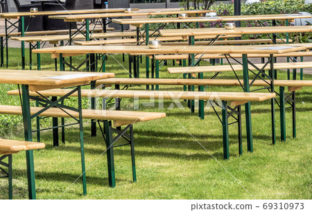 tables and chairs on a lawn to entertain guests outdoors 69310973