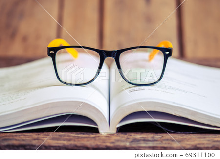 Glasses on the book blurred background 69311100