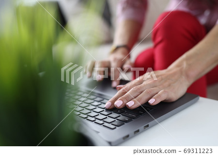 There is laptop on table. Female hands are typing text. There is laptop on table. Female hands are typing text. 69311223