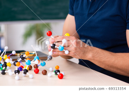 Young male scientist sitting in the classroom Young male scientist sitting in the classroom 69313354