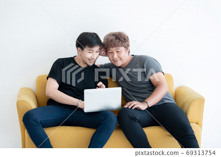Asian LGBT Gay Couple Using  Laptop Computer Together in the Liv 69313754