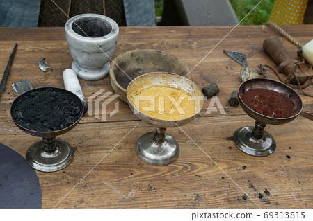 charcoal, sulfur, saltpeter in bowls for making black powder. Casting of lead bullets according to the technology of the 17th century charcoal, sulfur, saltpeter in bowls for making black powder. Casting of lead bullets according to the technology of the 17th century 69313815