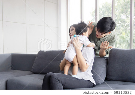 Asian LGBTQ Couple Play with Their Adopted Baby on the Sofa 69313822