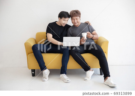 Asian LGBT Gay Couple Using  Laptop Computer Together in the Liv 69313899