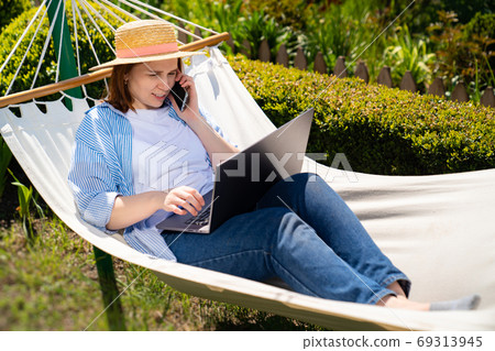 woman lies in hammock and working on computer 69313945
