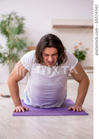 Young male starting day with morning exercises Young male starting day with morning exercises 69314342