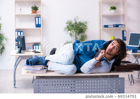 Male employee coming to work straight from bed 69314701