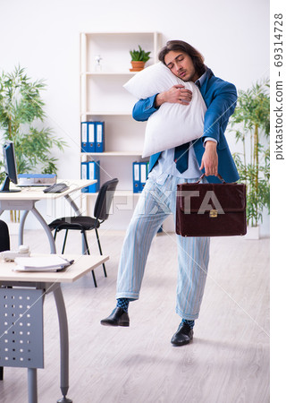 Male employee coming to work straight from bed Male employee coming to work straight from bed 69314728