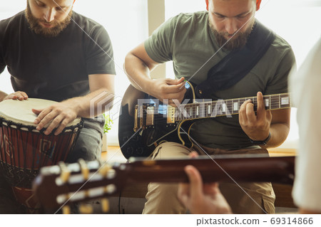 Musician band jamming together in art workplace with instruments Musician band jamming together in art workplace with instruments 69314866