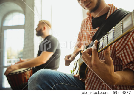 Musician band jamming together in art workplace with instruments Musician band jamming together in art workplace with instruments 69314877