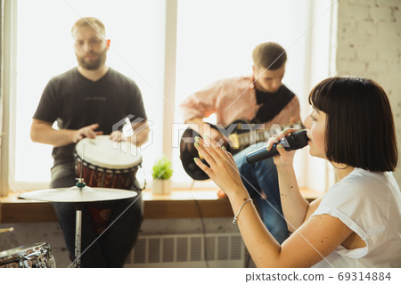 Musician band jamming together in art workplace with instruments Musician band jamming together in art workplace with instruments 69314884