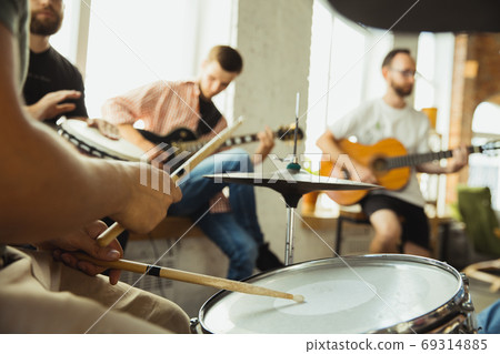 Musician band jamming together in art workplace with instruments Musician band jamming together in art workplace with instruments 69314885