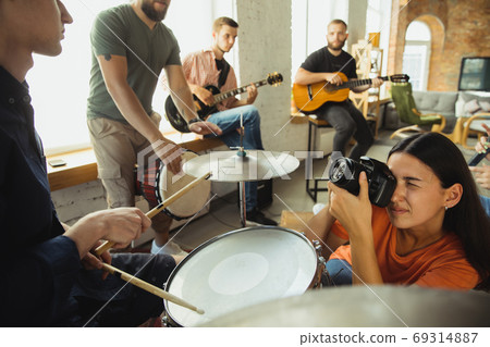 Musician band jamming together in art workplace with instruments Musician band jamming together in art workplace with instruments 69314887
