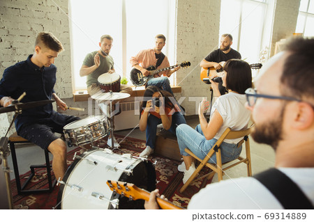 Musician band jamming together in art workplace with instruments Musician band jamming together in art workplace with instruments 69314889