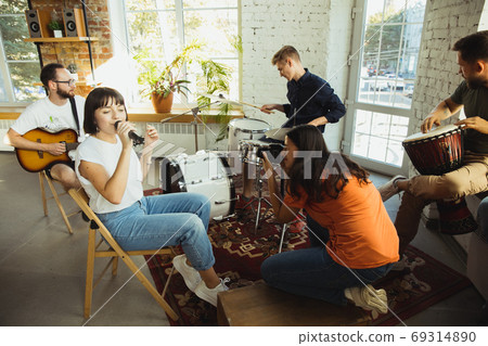 Musician band jamming together in art workplace with instruments Musician band jamming together in art workplace with instruments 69314890