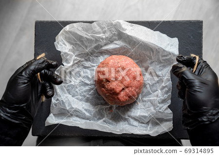 minced meat on paper, stone tray, black gloves 69314895