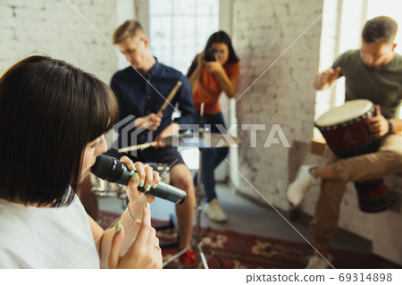 Musician band jamming together in art workplace with instruments Musician band jamming together in art workplace with instruments 69314898