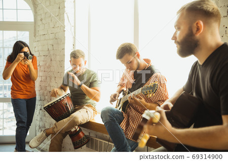 Musician band jamming together in art workplace with instruments Musician band jamming together in art workplace with instruments 69314900