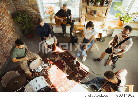 Musician band jamming together in art workplace with instruments Musician band jamming together in art workplace with instruments 69314902