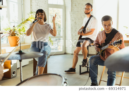 Musician band jamming together in art workplace with instruments Musician band jamming together in art workplace with instruments 69314971