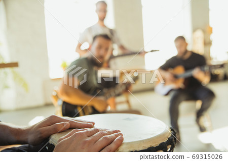 Musician band jamming together in art workplace with instruments Musician band jamming together in art workplace with instruments 69315026
