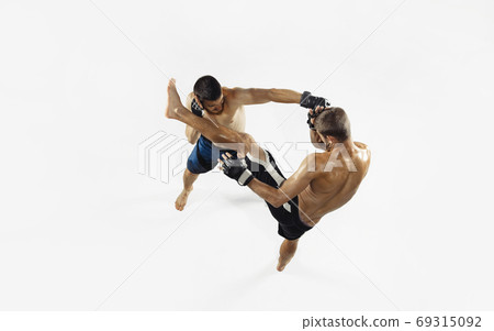 Two professional MMA fighters boxing isolated on white studio background, dynamic and motion. Top view Two professional MMA fighters boxing isolated on white studio background, dynamic and motion. Top view 69315092