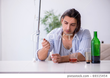 Young man in alcohol addiction treatment concept 69315454