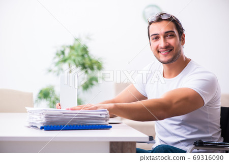 Young disabled man working from house 69316090