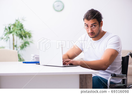 Young disabled man working from house 69316098