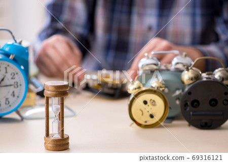 Young male watchmaker working in the workshop Young male watchmaker working in the workshop 69316121