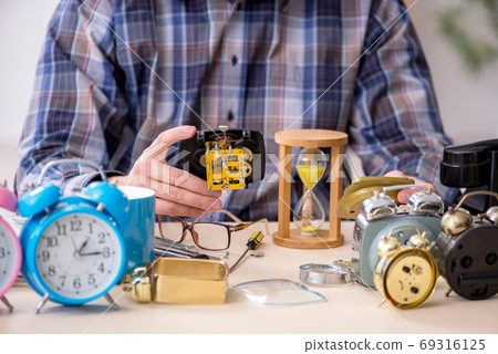 Young male watchmaker working in the workshop 69316125