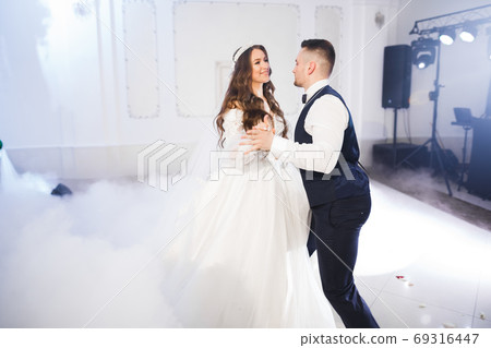 Beautiful wedding couple just married and dancing their first dance Beautiful wedding couple just married and dancing their first dance 69316447