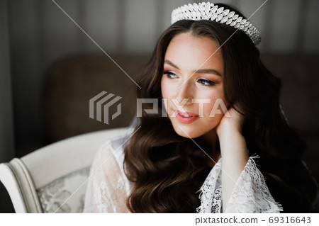Luxury bride in white dress posing while preparing for the wedding ceremony Luxury bride in white dress posing while preparing for the wedding ceremony 69316643