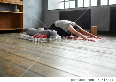 Woman doing forward bend yoga exercise, Balasana, Child Pose, stretching spin Woman doing forward bend yoga exercise, Balasana, Child Pose, stretching spin 69316845