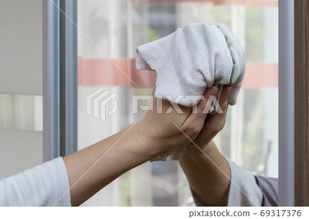 Hand of girl wipes a mirror with a rag at home Hand of girl wipes a mirror with a rag at home 69317376