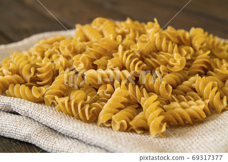 Dark yellow raw whole grain pasta with bran on Dark yellow raw whole grain pasta with bran on 69317377
