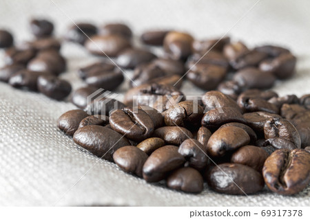 Close-up of coffee beans on linen fabric. 69317378