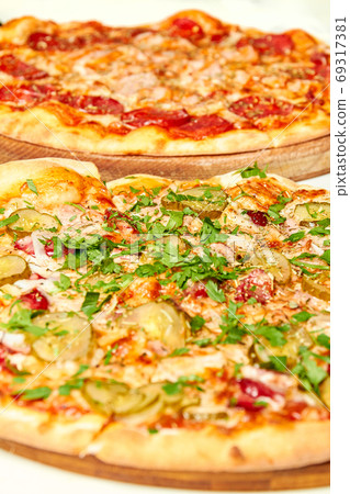 Fresh pizza with bacon, pickles and cheese on a Fresh pizza with bacon, pickles and cheese on a 69317381