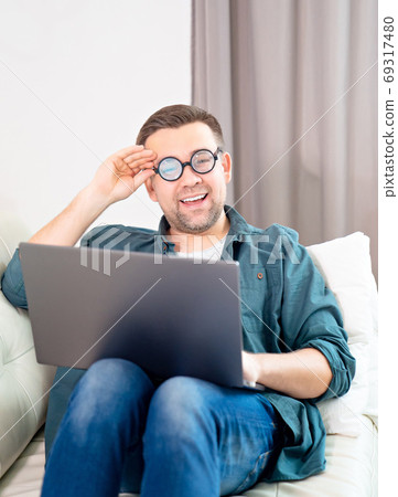 male freak with glasses working online at home. male freak with glasses working online at home. 69317480
