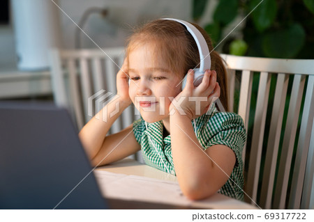 girl in headphones listens online lesson on laptop girl in headphones listens online lesson on laptop 69317722