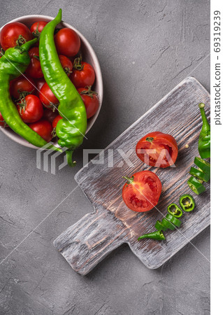 Fresh ripe tomatoes in bowl near to old wooden cutting board Fresh ripe tomatoes in bowl near to old wooden cutting board 69319239