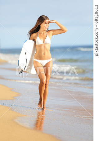 Beach fun surfer woman going surfing with bodyboard 69319613