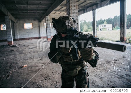 Soldier in full US MARSOC equipment entering abandoned building, aiming different angles with MK18 assault rifle Soldier in full US MARSOC equipment entering abandoned building, aiming different angles with MK18 assault rifle 69319795