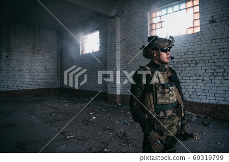 Front view close up of caucasian soldier with a rifle stand guard securing territory looking around. 69319799