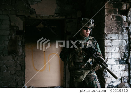 Soldier in combat. Urban combat training, soldier entering abandoned building. Anti terrorist operation battlefield training. Soldier in combat. Urban combat training, soldier entering abandoned building. Anti terrorist operation battlefield training. 69319810