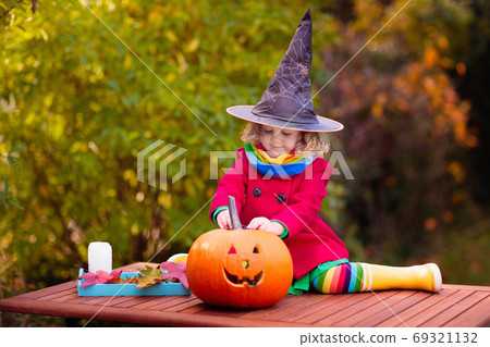 Kids carving Halloween pumpkin. Kids carving Halloween pumpkin. 69321132