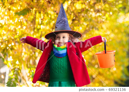Kids trick or treat on Halloween night. 69321136