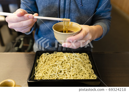 Woman enjoying Japanese soba noodle Woman enjoying Japanese soba noodle 69324218
