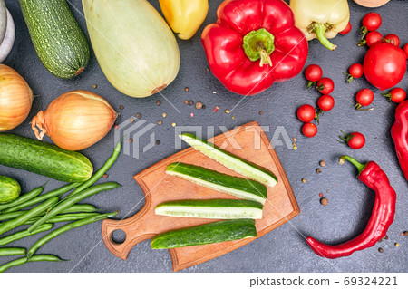 chopped cucumber on a wooden board with vegetables one 69324221